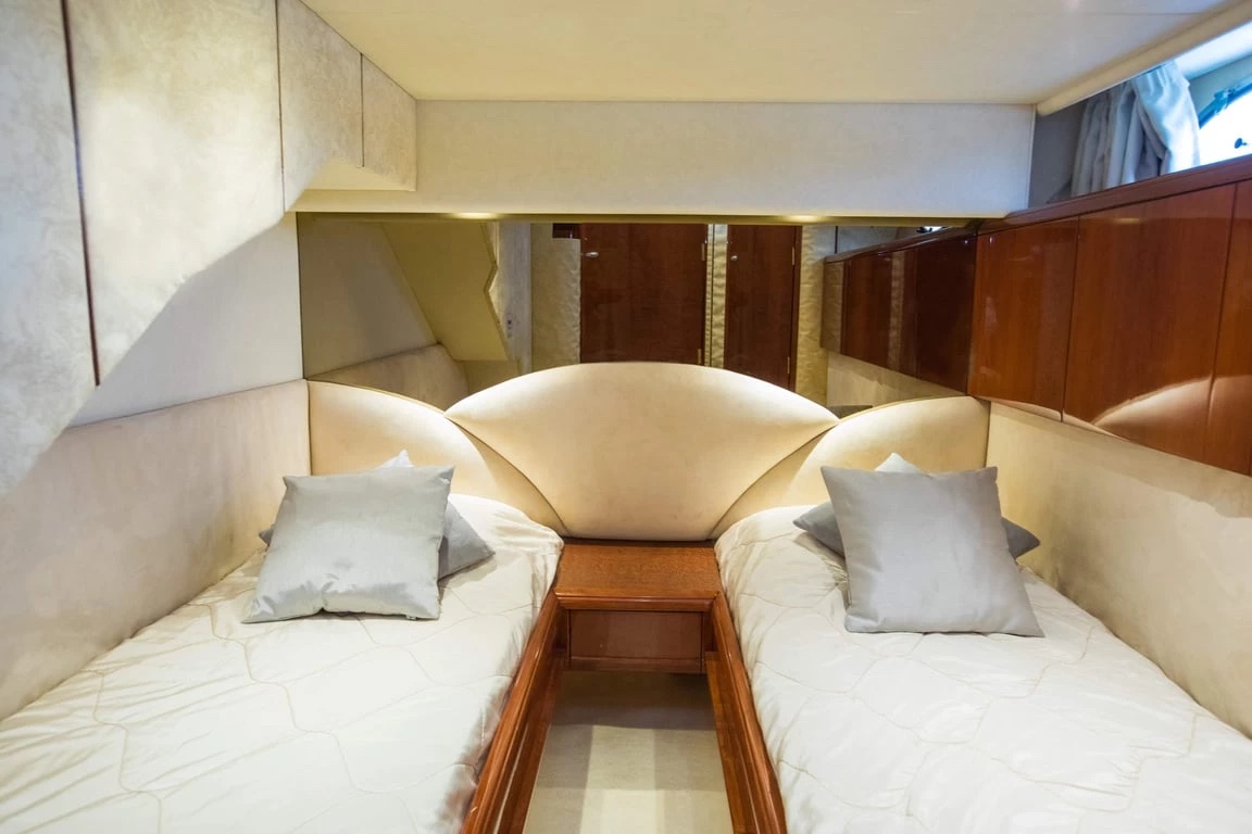 Twin guest cabin aboard the Malavi 55 with two single berths and cream upholstery