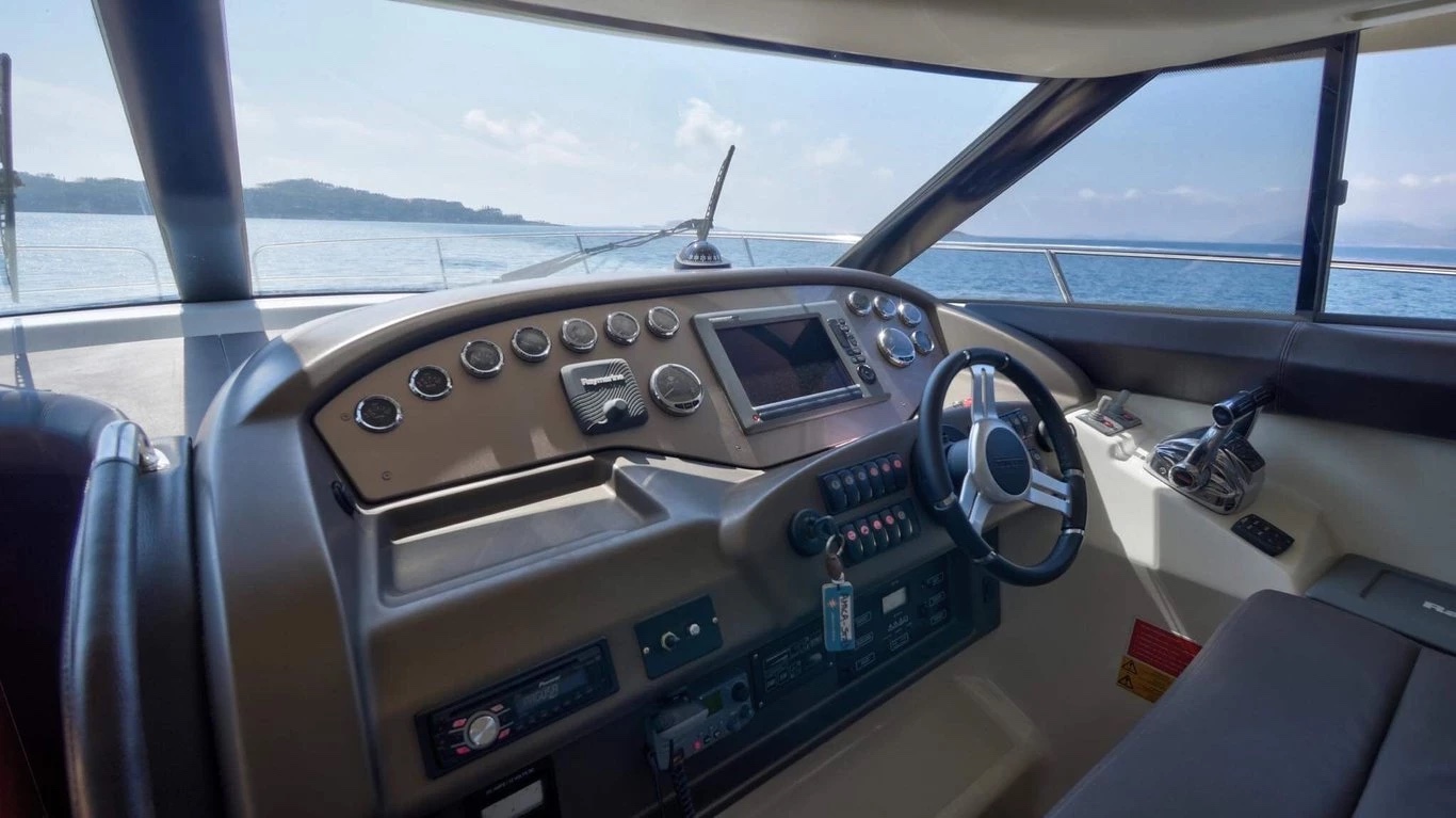 Close-up of the Prestige 440 Fly lower helm with Raymarine chartplotter, engine gauges and steering wheel
