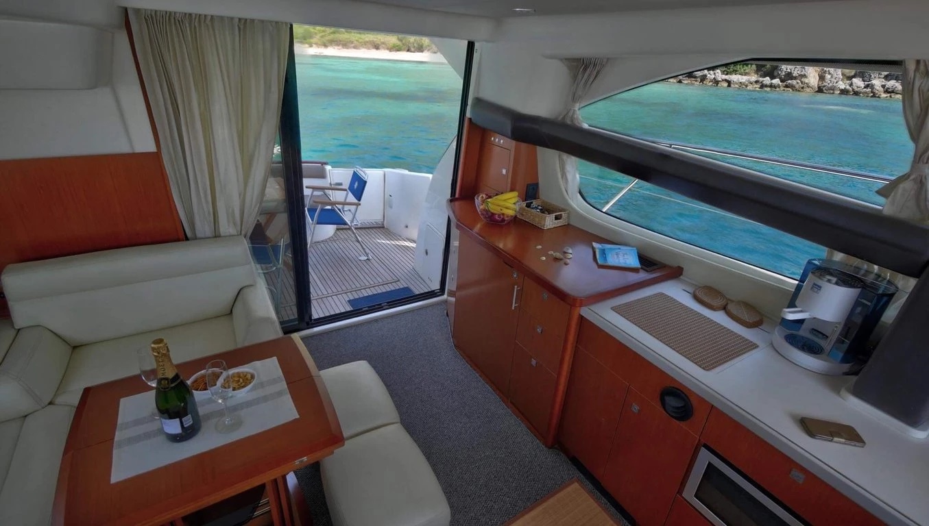View aft through the Prestige 440 Fly saloon, past the galley to the open cockpit door and teak deck