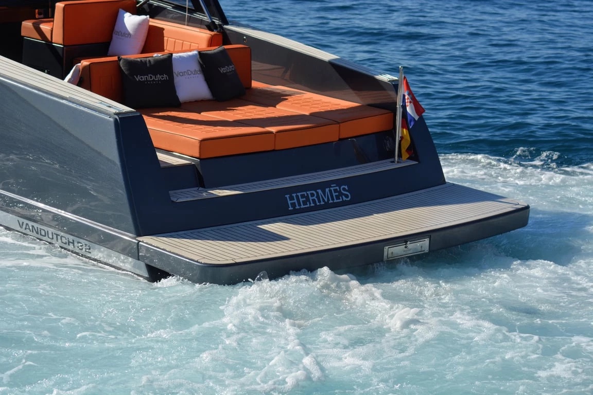 Teak swim platform and Hermès transom of the VanDutch 32 underway, Croatian flag flying over the churned wake